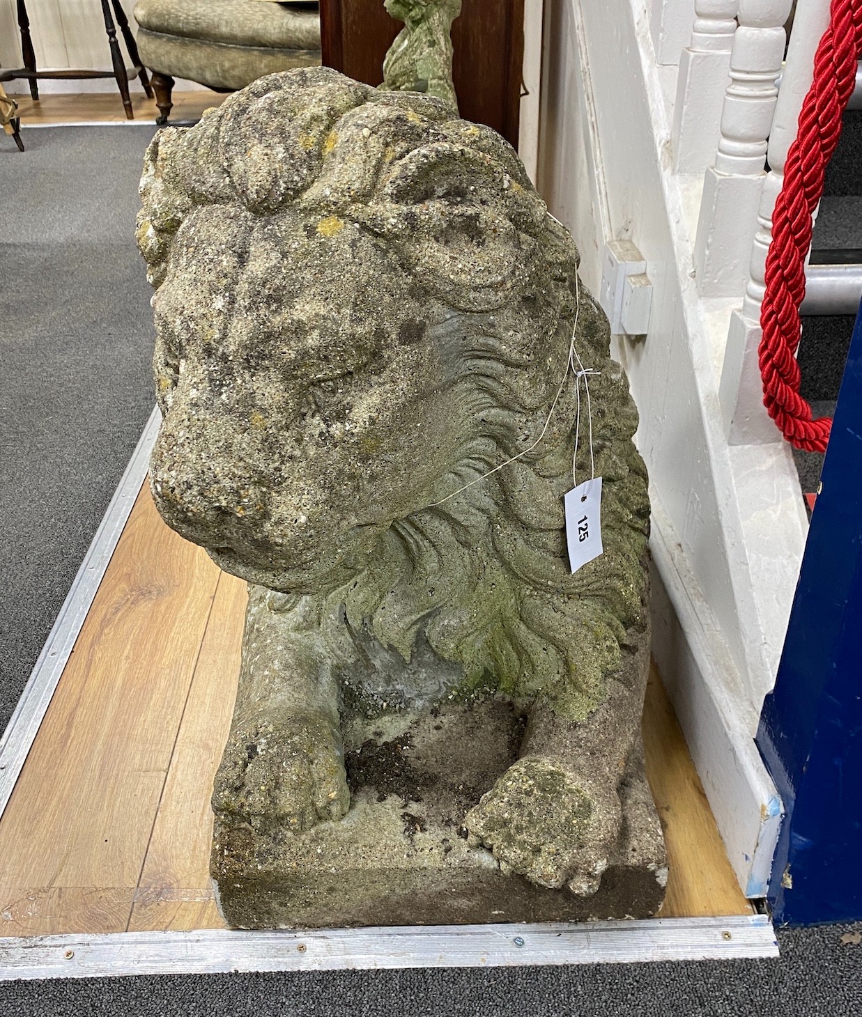 A large reconstituted stone recumbent lion garden ornament, length 91cm, depth 33cm, height 60cm